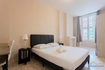 a bedroom with a large white bed with a window at Nice Tête au carré 3 pièces proche coulée verte in Nice