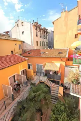 an outdoor patio with tables and chairs and buildings at Joli Studio du Paillon in Nice