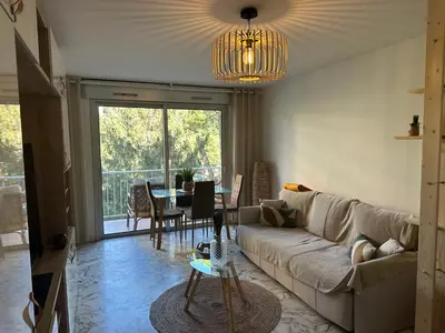 a dining room with a table and chairs and a balcony at Studio près de la mer in Cagnes-sur-Mer