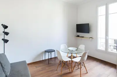 a living room with a table and chairs and a tv at Modern & Central Apartment in Nice