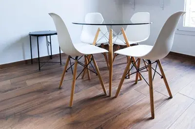 a table with four white chairs and a glass table at Modern & Central Apartment in Nice