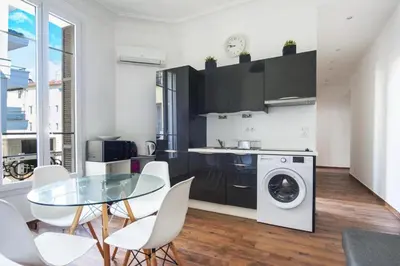 a kitchen with a glass table and a washing machine at Modern & Central Apartment in Nice