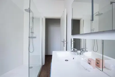 a white bathroom with a sink and a shower at Modern & Central Apartment in Nice