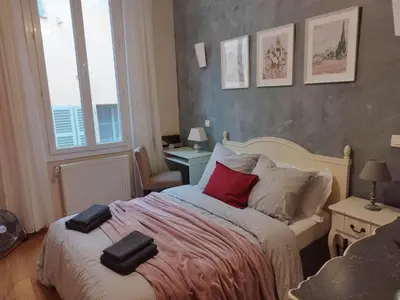 a bedroom with a bed with red pillows on it at Old town Nice, near Flower Market in Nice