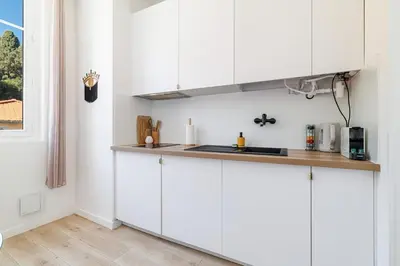 a kitchen with white cabinets and a counter top at Cozy and bright appartement - Port of Nice in Nice