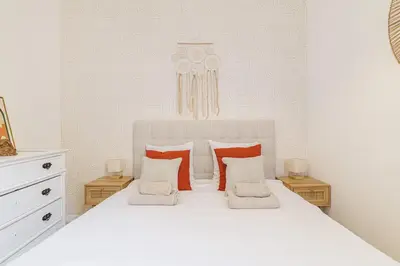 a bedroom with a white bed with red and white pillows at Cozy and bright appartement - Port of Nice in Nice