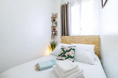 a bedroom with a bed with white sheets and pillows at Centre Nice - 10 min plage - 5 min des transports en commun in Nice