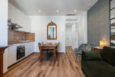 a kitchen and living room with a table and a couch at Centre Nice - 10 min plage - 5 min des transports en commun in Nice