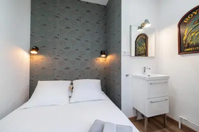 a bedroom with a white bed and a sink at Centre Nice - 10 min plage - 5 min des transports en commun in Nice
