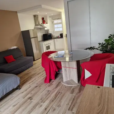 a living room with a table and a kitchen at F1 cap 3000 in Saint-Laurent-du-Var
