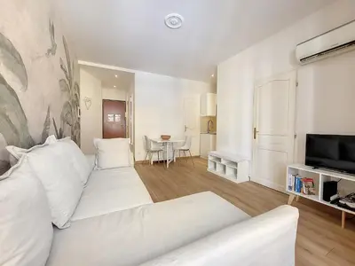 a white living room with a white couch and a television at Nestor&Jeeves - SEA AND SUN - Central - Close sea in Nice