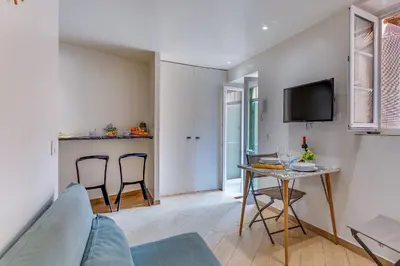 a living room with a table and chairs and a tv at ESCAPADE AP4463 By Riviera Holiday Homes in Villefranche-sur-Mer