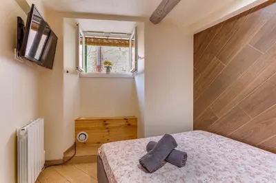 a bedroom with a bed and a tv on the wall at ESCAPADE AP4463 By Riviera Holiday Homes in Villefranche-sur-Mer