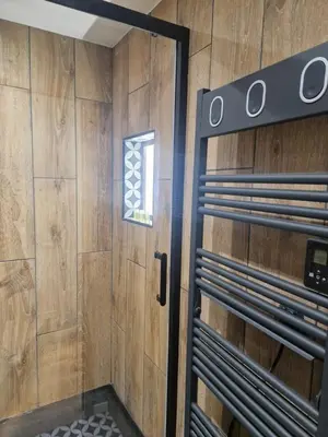 a bathroom with a shower with a wooden wall at PASTO GAUCHE Appartement Nice 6P in Nice