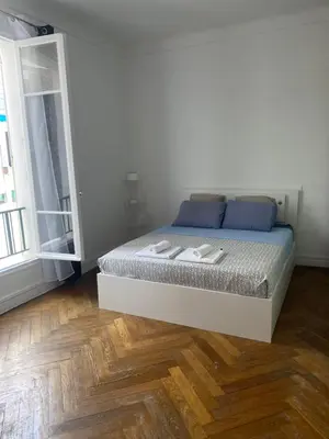 a bedroom with a bed with blue pillows and a wooden floor at La casa in Nice