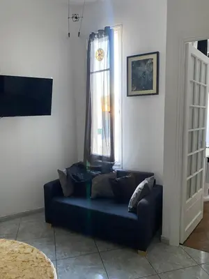 a blue couch in a living room with a window at La casa in Nice