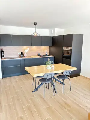 a kitchen with a wooden table and two chairs at Seaside Azur in Saint-Laurent-du-Var