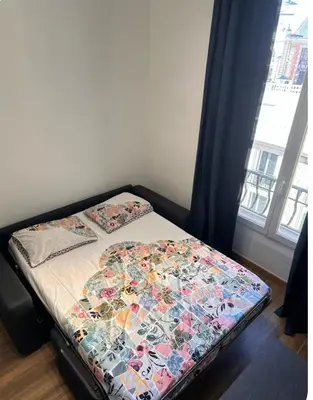 a small bed in a room with a window at Jolie studio in Nice