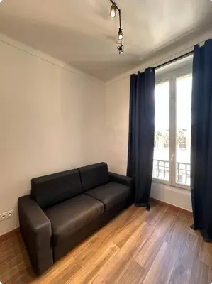a living room with a couch and a window at Jolie studio in Nice
