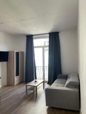 a living room with a couch and a large window at Jolie studio in Nice