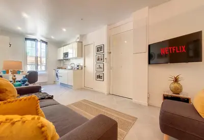 a living room with a couch and a tv on a wall at Nestor&Jeeves - L ANCRE - Port Area - Close Old Town in Nice