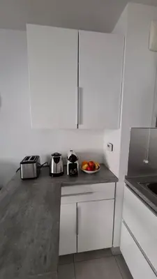 a kitchen with white cabinets and a bowl of fruit on a counter at Beautiful 43m2 with two double beds everything nearby in Nice