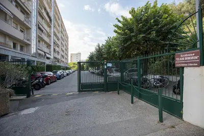 a green gate with a parking lot with parked cars at Breathtaking panoramic view of Nice ! in Nice