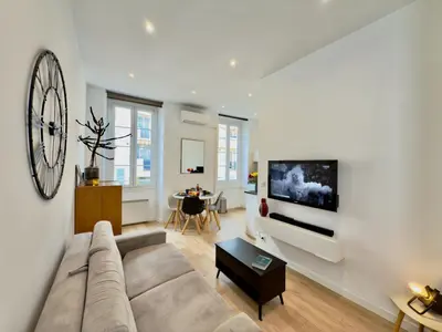 a living room with a couch and a large clock on the wall at Ze Perfect Place - Chic & Cosy au Port Nice - AC in Nice