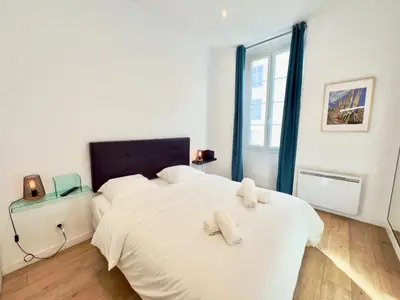 a bedroom with a large white bed with two towels on it at Ze Perfect Place - Chic & Cosy au Port Nice - AC in Nice
