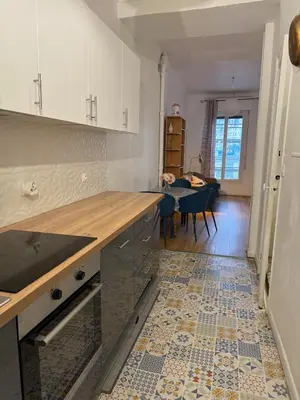 a kitchen with a counter and a dining room at Deux pièces Libération - Balcon in Nice