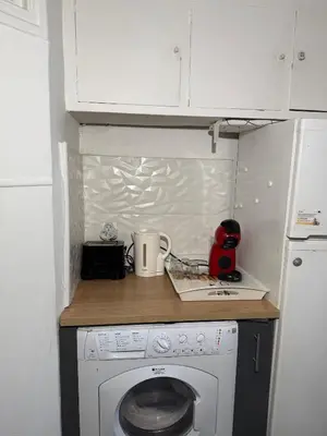 a small kitchen with a washing machine and a counter at Deux pièces Libération - Balcon in Nice