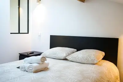 a bed with two pillows and towels on it at Appartement Original cœur de ville -AC- in Nice