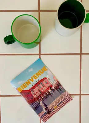 a magazine sitting on a counter next to a cup of coffee at Under the Citrus Trees in Nice