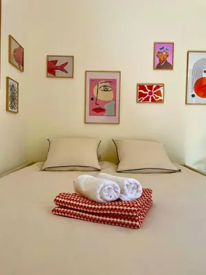 a bed with a pile of towels on it at Under the Citrus Trees in Nice