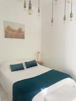 a white bedroom with a bed with blue sheets at Appartment with private garden in city center Nice in Nice