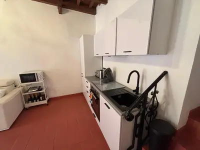a small kitchen with white cabinets and a sink at Morning Coffee & Cobblestones - A True French Village Stay in Villefranche-sur-Mer