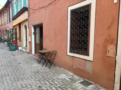 a table and chairs sitting outside of a building at Morning Coffee & Cobblestones - A True French Village Stay in Villefranche-sur-Mer