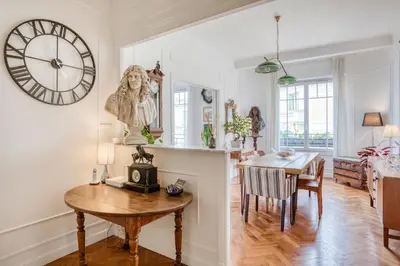 a dining room with a table and a clock on the wall at Chambre chez l'habitant - Centre Nice 10 min de la plage in Nice