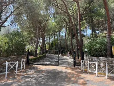 a gate in a park with a person on a bike at Pleine vue mer au calme - Parking, Piscine, Tennis in Nice
