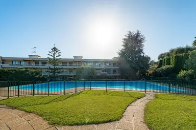 a fence around a swimming pool in front of a building at Pleine vue mer au calme - Parking, Piscine, Tennis in Nice