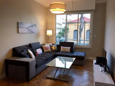 a living room with a blue couch and a table at 115 Promenade des Anglais in Nice