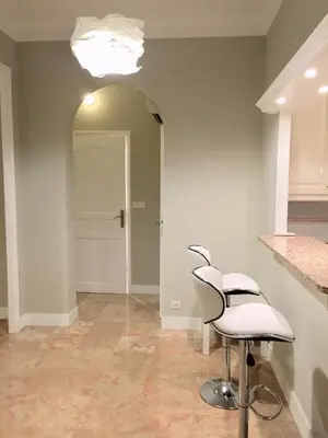 a hallway with two white stools and a white door at 115 Promenade des Anglais in Nice