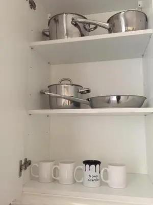 a kitchen shelf with pots and pans on it at 115 Promenade des Anglais in Nice
