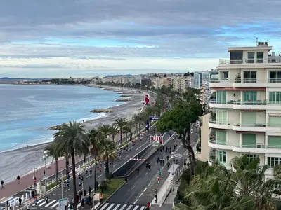 a view of a beach with a building and the ocean at 115 Promenade des Anglais in Nice