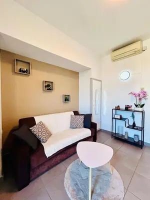 a living room with a couch and a table at Studio Rénové et Meublé Le Cœur de Nice à Vos Pieds in Nice
