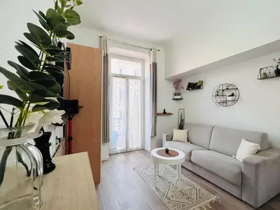 a living room with a couch and a table at Charmant Studio Rénové en Plein Centre de Nice in Nice