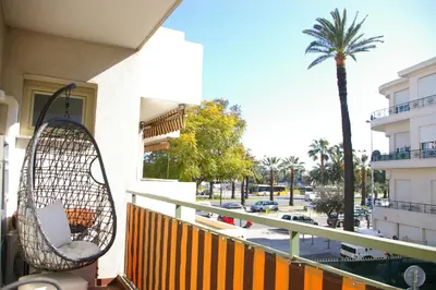 a balcony with a swing and a palm tree at Studio Proche mer Nice in Nice