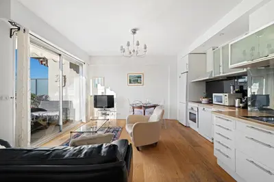 a kitchen and living room with a couch and a table at Terrasse ensoleillée sur les toits de Nice in Nice