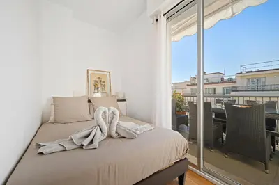 a bedroom with a bed and a large window at Terrasse ensoleillée sur les toits de Nice in Nice