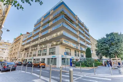 a large building on a city street with cars parked in front at FRANCIA AZUR AP4483 by RIVIERA HOLIDAY HOMES in Nice